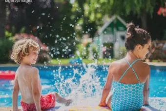 Deux enfants avec des pieds éclaboussant dans une piscine